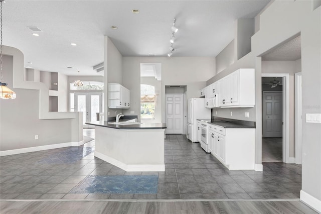 81 Brownstone Ln, Palm Coast, FL 32137 - kitchen with dark countertops, a chandelier, and white cabinets