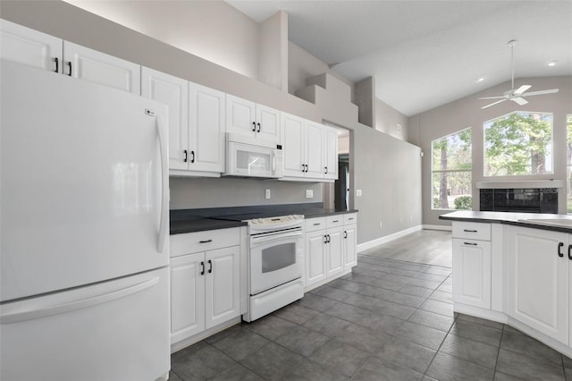 81 Brownstone Ln, Palm Coast, FL 32137 - kitchen featuring white appliances, dark countertops, ceiling fan, lofted ceiling, and white cabinets