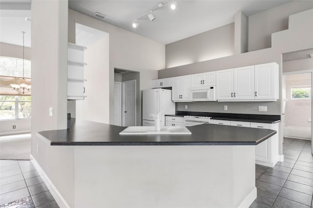 81 Brownstone Ln, Palm Coast, FL 32137 - kitchen with white appliances, dark countertops, open shelves, and tile patterned flooring