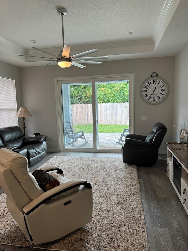 146 Via Madrid Dr, Ormond Beach, FL 32176 - living area with a ceiling fan, dark wood-type flooring, a tray ceiling, ornamental molding, and a textured ceiling