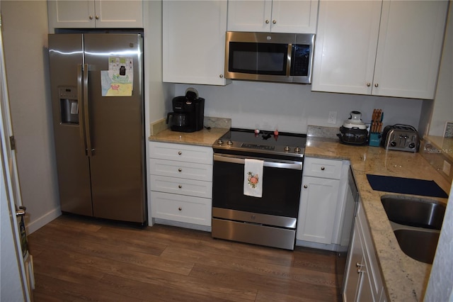 146 Via Madrid Dr, Ormond Beach, FL 32176 - kitchen featuring appliances with stainless steel finishes, white cabinetry, and light stone countertops