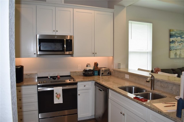 146 Via Madrid Dr, Ormond Beach, FL 32176 - kitchen featuring appliances with stainless steel finishes, white cabinetry, and light stone counters