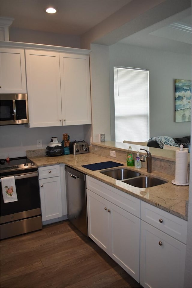 146 Via Madrid Dr, Ormond Beach, FL 32176 - kitchen with appliances with stainless steel finishes, white cabinets, recessed lighting, light stone countertops, and dark wood-type flooring