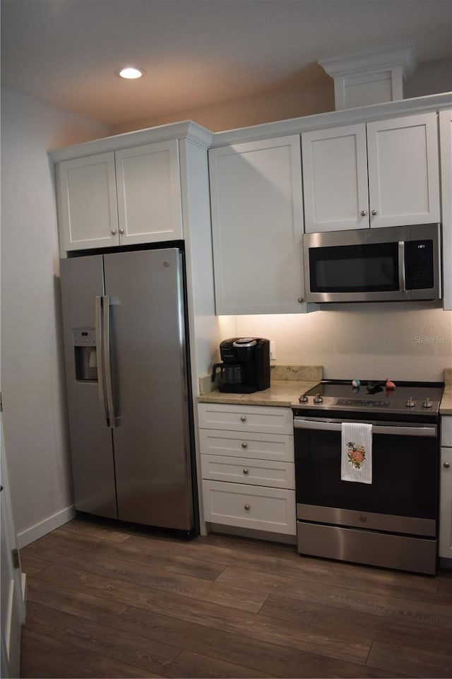 146 Via Madrid Dr, Ormond Beach, FL 32176 - kitchen featuring stainless steel appliances, white cabinets, recessed lighting, dark wood finished floors, and light stone countertops