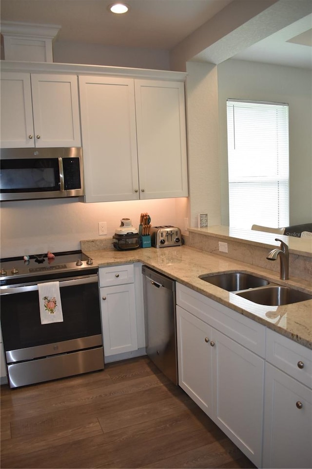 146 Via Madrid Dr, Ormond Beach, FL 32176 - kitchen featuring appliances with stainless steel finishes, white cabinetry, recessed lighting, light stone counters, and dark wood finished floors