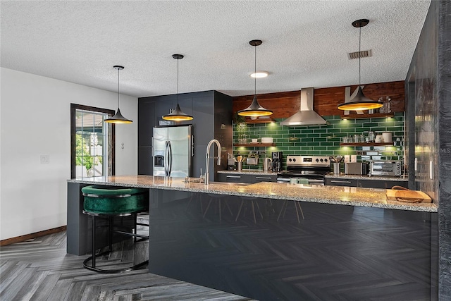 8 White Horse Ln, Palm Coast, FL 32164 - bar featuring appliances with stainless steel finishes, wall chimney exhaust hood, a textured ceiling, tasteful backsplash, and pendant lighting