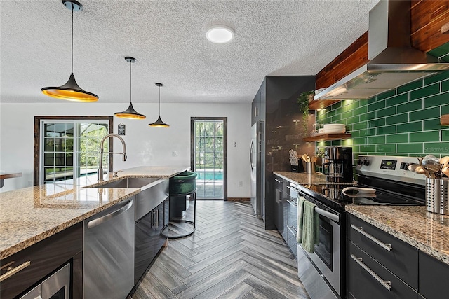 8 White Horse Ln, Palm Coast, FL 32164 - kitchen with stainless steel appliances, wall chimney range hood, a textured ceiling, hanging light fixtures, and light stone countertops