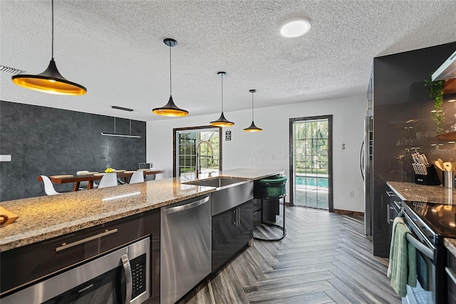 8 White Horse Ln, Palm Coast, FL 32164 - kitchen with stainless steel appliances, a textured ceiling, decorative light fixtures, and plenty of natural light