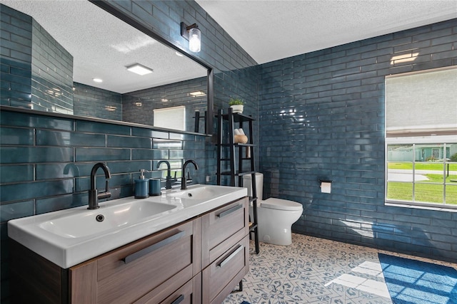 8 White Horse Ln, Palm Coast, FL 32164 - bathroom featuring a textured ceiling, double vanity, and tile walls
