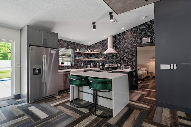 66 Randolph Dr, Palm Coast, FL 32164 - kitchen with stainless steel appliances, light countertops, a center island, open shelves, and wallpapered walls