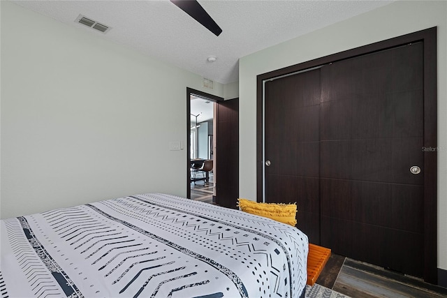 66 Randolph Dr, Palm Coast, FL 32164 - bedroom featuring dark wood finished floors, a ceiling fan, a closet, and a textured ceiling