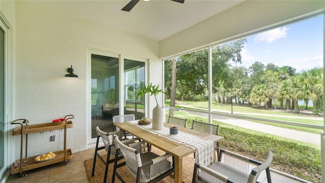 455 Riverfront Dr Unit A104, Palm Coast, FL 32137 - sunroom with a ceiling fan, outdoor dining area, and view of wooded area