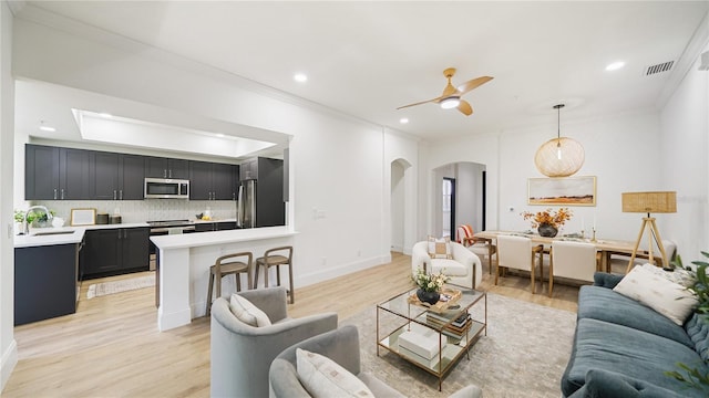455 Riverfront Dr Unit A203, Palm Coast, FL 32137 - living room with arched walkways, ornamental molding, light wood finished floors, a ceiling fan, and recessed lighting