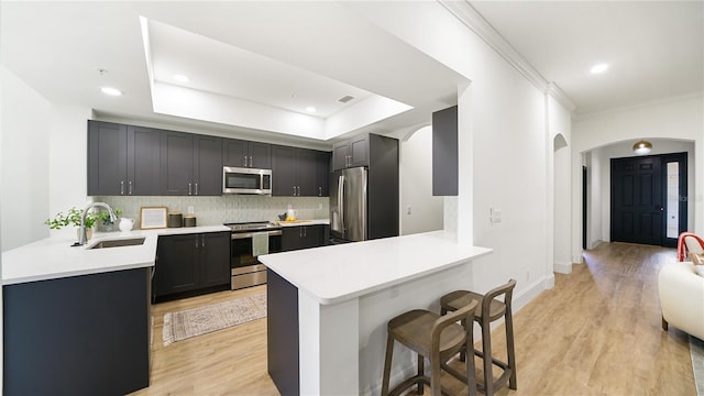 455 Riverfront Dr Unit A203, Palm Coast, FL 32137 - kitchen featuring appliances with stainless steel finishes, a peninsula, arched walkways, a kitchen bar, and crown molding
