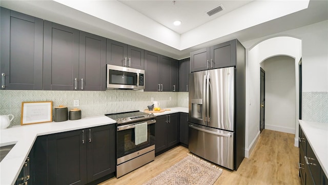 455 Riverfront Dr Unit A203, Palm Coast, FL 32137 - kitchen with appliances with stainless steel finishes, light wood-style flooring, tasteful backsplash, and arched walkways