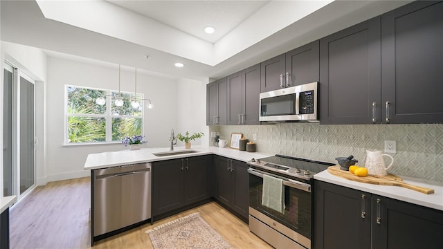 455 Riverfront Dr Unit A203, Palm Coast, FL 32137 - kitchen featuring stainless steel appliances, a peninsula, light wood finished floors, light countertops, and backsplash
