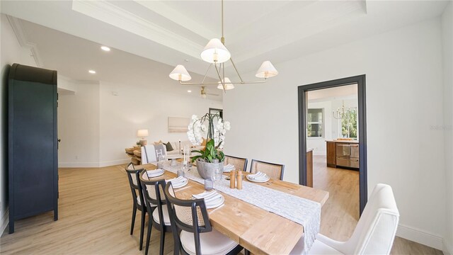 455 Riverfront Dr Unit A204, Palm Coast, FL 32137 - dining space featuring light wood-style flooring, a tray ceiling, a chandelier, recessed lighting, and ornamental molding