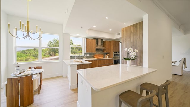 455 Riverfront Dr Unit A204, Palm Coast, FL 32137 - kitchen featuring brown cabinets, modern cabinets, a peninsula, wall chimney range hood, and recessed lighting