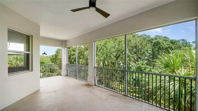 455 Riverfront Dr Unit A301, Palm Coast, FL 32137 - unfurnished sunroom featuring a textured wall, concrete flooring, and view of wooded area