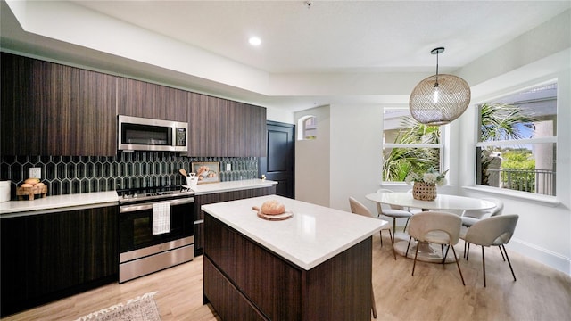 455 Riverfront Dr Unit A302, Palm Coast, FL 32137 - kitchen with appliances with stainless steel finishes, light countertops, tasteful backsplash, a kitchen island, and hanging light fixtures