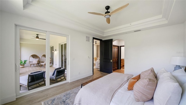 455 Riverfront Dr Unit A302, Palm Coast, FL 32137 - bedroom with a raised ceiling, arched walkways, wood finished floors, ceiling fan, and connected bathroom