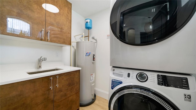 455 Riverfront Dr Unit A302, Palm Coast, FL 32137 - laundry area with estacked washer and dryer, electric water heater, cabinet space, and light wood-type flooring