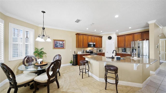30 Cortes Ct, Palm Coast, FL 32137 - kitchen featuring appliances with stainless steel finishes, a chandelier, a breakfast bar, a spacious island, and crown molding