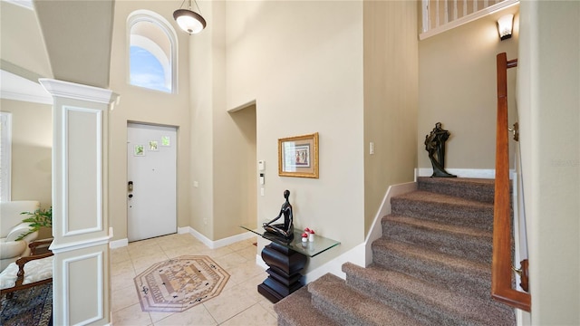 30 Cortes Ct, Palm Coast, FL 32137 - entryway featuring a towering ceiling, decorative columns, stairway, and light tile patterned flooring