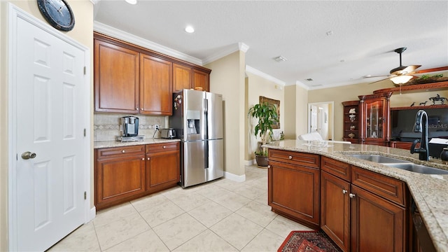 30 Cortes Ct, Palm Coast, FL 32137 - kitchen featuring stainless steel refrigerator with ice dispenser, ornamental molding, brown cabinetry, light tile patterned floors, and light stone countertops
