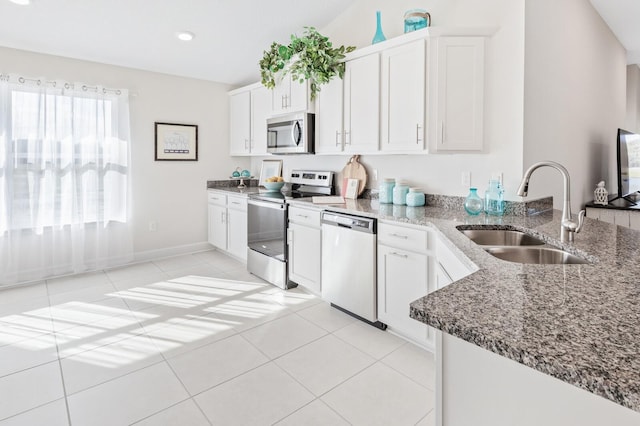 88 Rae Dr, Palm Coast, FL 32164 - kitchen featuring stainless steel appliances, stone countertops, light tile patterned flooring, white cabinets, and a peninsula