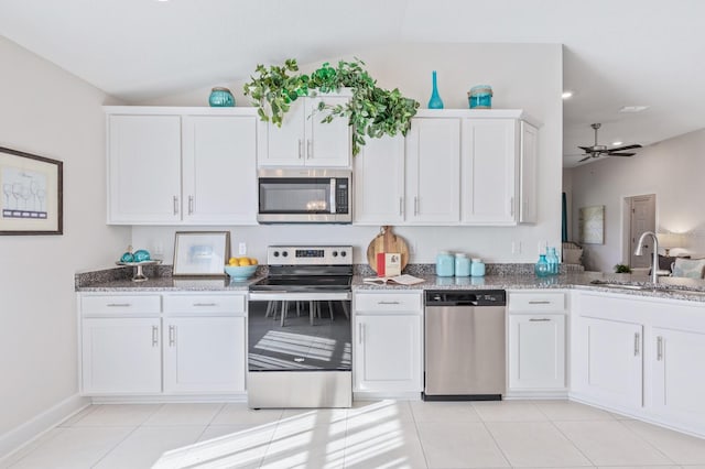 88 Rae Dr, Palm Coast, FL 32164 - kitchen with stainless steel appliances, lofted ceiling, light stone countertops, white cabinets, and a ceiling fan