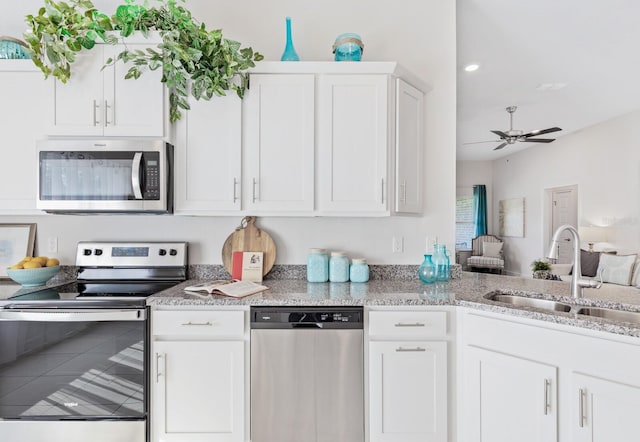 88 Rae Dr, Palm Coast, FL 32164 - kitchen featuring stainless steel appliances, a ceiling fan, white cabinetry, light stone counters, and recessed lighting