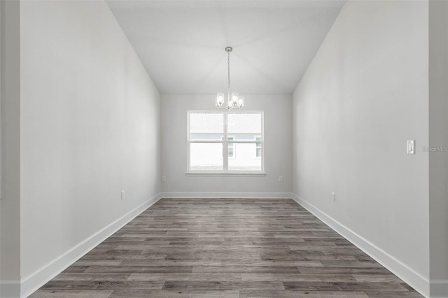 12 Wainshire Pl, Palm Coast, FL 32164 - empty room featuring a chandelier, vaulted ceiling, and dark wood finished floors