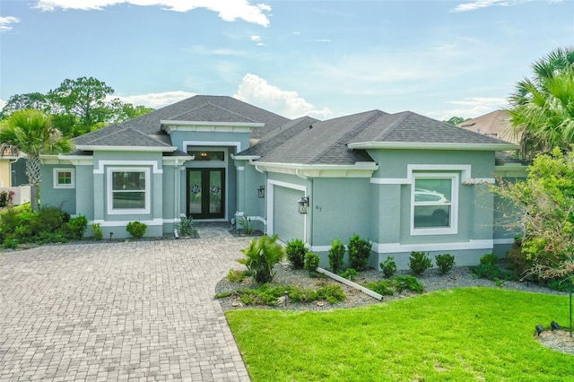 67 N Lakewalk Dr, Palm Coast, FL 32137 - view of front of home with french doors, an attached garage, stucco siding, and decorative driveway