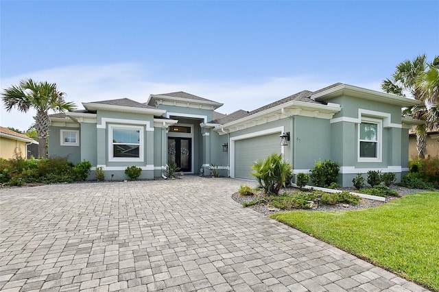 67 N Lakewalk Dr, Palm Coast, FL 32137 - prairie-style home with stucco siding, decorative driveway, an attached garage, french doors, and roof with shingles