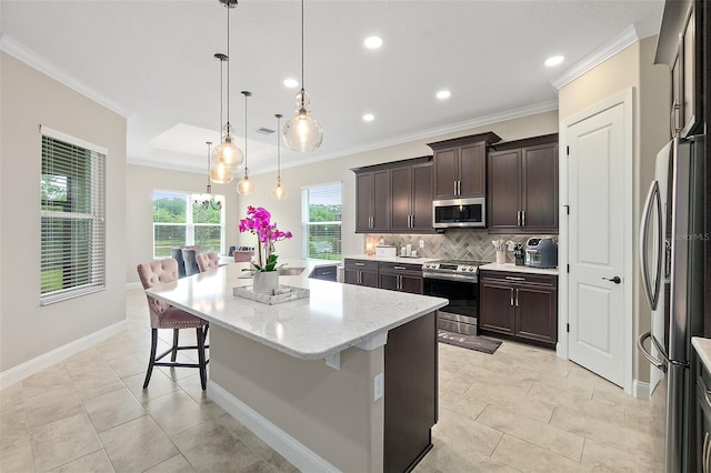 67 N Lakewalk Dr, Palm Coast, FL 32137 - kitchen with appliances with stainless steel finishes, a center island, tasteful backsplash, crown molding, and a breakfast bar