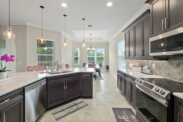 67 N Lakewalk Dr, Palm Coast, FL 32137 - kitchen featuring stainless steel appliances, a tray ceiling, decorative backsplash, pendant lighting, and ornamental molding