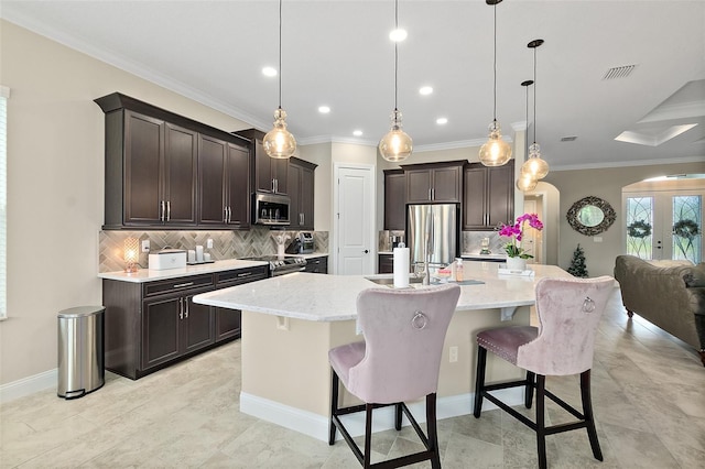 67 N Lakewalk Dr, Palm Coast, FL 32137 - kitchen with stainless steel appliances, backsplash, dark brown cabinets, a breakfast bar, and a large island with sink