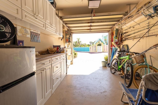 3000 Ocean Shore Blvd Unit 18, Ormond Beach, FL 32176 - garage featuring freestanding refrigerator and a garage door opener