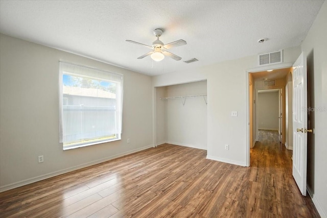 37 Lindsay Dr, Palm Coast, FL 32137 - unfurnished bedroom featuring wood finished floors, a closet, a textured ceiling, and a ceiling fan