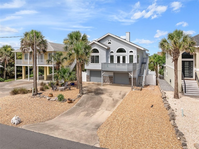 1115 N Central Ave, Flagler Beach, FL 32136 - view of front of property with stairway, an attached garage, stucco siding, concrete driveway, and stone siding