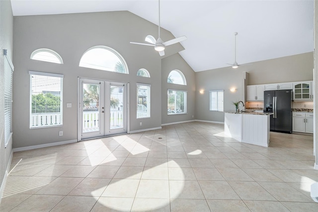 1115 N Central Ave, Flagler Beach, FL 32136 - unfurnished living room featuring high vaulted ceiling, ceiling fan, light tile patterned flooring, and french doors