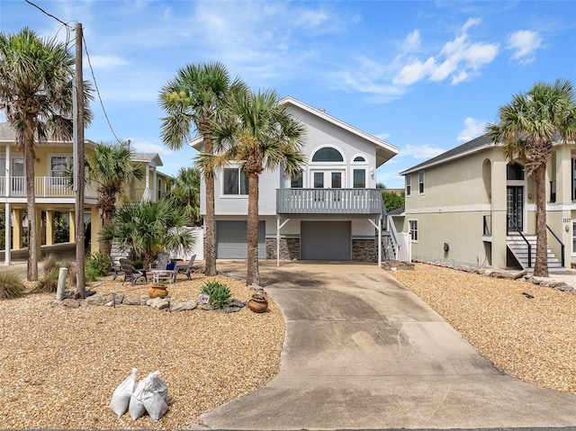 1115 N Central Ave, Flagler Beach, FL 32136 - view of front of home featuring a garage, stairs, driveway, stucco siding, and stone siding