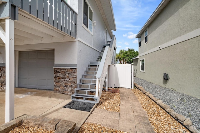 1115 N Central Ave, Flagler Beach, FL 32136 - doorway to property featuring stucco siding, an attached garage, and stone siding