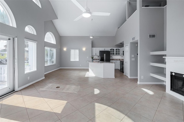 1115 N Central Ave, Flagler Beach, FL 32136 - kitchen with black refrigerator with ice dispenser, high vaulted ceiling, open floor plan, ceiling fan, and light tile patterned floors
