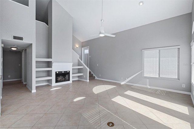 1115 N Central Ave, Flagler Beach, FL 32136 - unfurnished living room featuring built in features, high vaulted ceiling, light tile patterned flooring, ceiling fan, and a fireplace