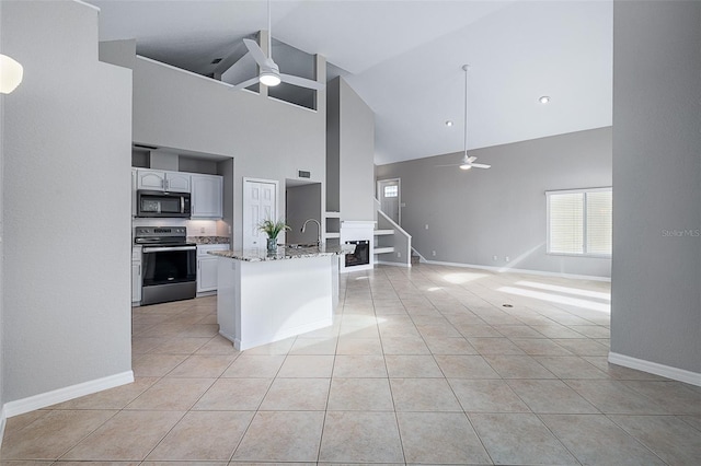 1115 N Central Ave, Flagler Beach, FL 32136 - kitchen featuring stainless steel electric stove, black microwave, ceiling fan, high vaulted ceiling, and open floor plan