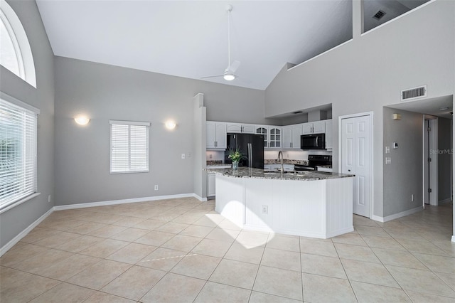 1115 N Central Ave, Flagler Beach, FL 32136 - kitchen featuring black appliances, high vaulted ceiling, a ceiling fan, light tile patterned flooring, and dark stone countertops