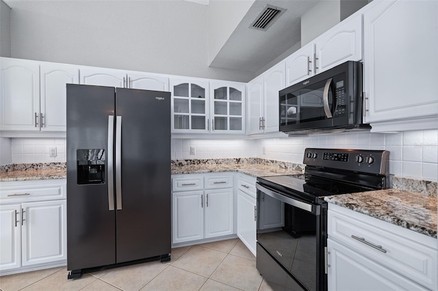 1115 N Central Ave, Flagler Beach, FL 32136 - kitchen featuring black appliances, decorative backsplash, glass insert cabinets, and light stone counters