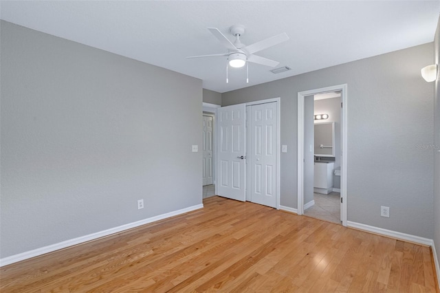 1115 N Central Ave, Flagler Beach, FL 32136 - unfurnished bedroom with light wood-style floors, ensuite bathroom, ceiling fan, and a closet
